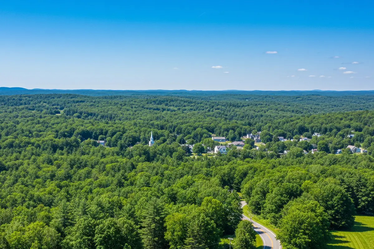 Aerial view of Rutland, Massachusetts surrounded by lush green trees and blue skies, representing clean air and natural beauty near Harmony Place.